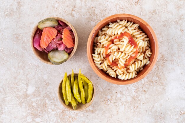 A clay bowl of tasty pasta with various vegetables 