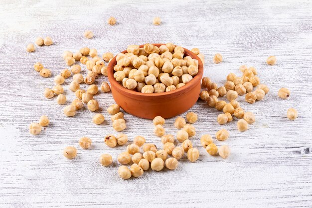 白い木製のテーブルに茶色のボウルハイアングルできれいにヘーゼルナッツ