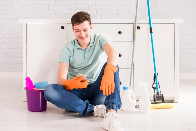 Cleaning concept with man holding smartphone