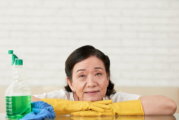 無料写真 テーブルの研磨から休憩を取って手袋で彼女の手にもたれてクリーニング女性