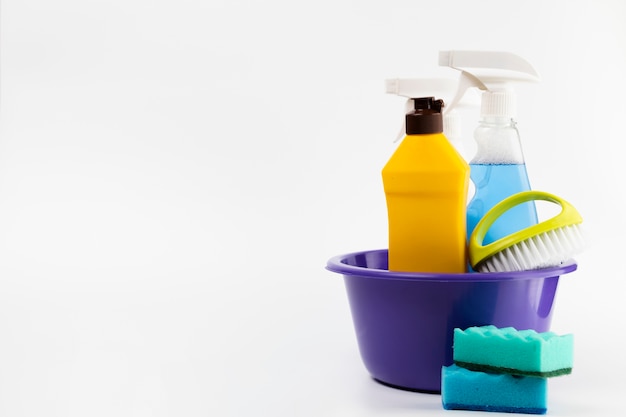 Cleaning products in basin with blue sponges