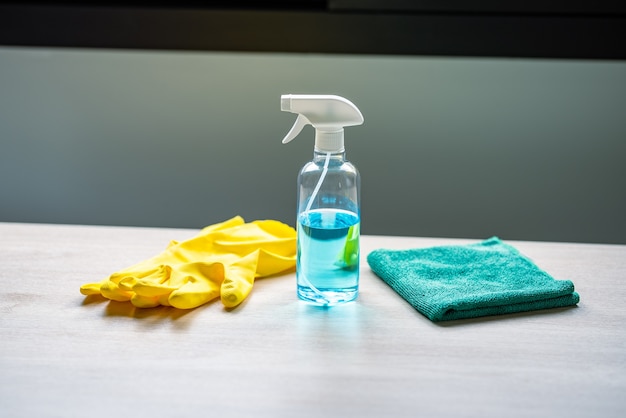 Cleaning supplies are placed on a wooden table for cleaning.