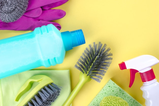 Cleaning supplies over yellow background