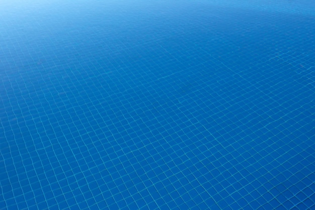Бесплатное фото Чистая голубая вода в бассейне сквозь солнечный свет. водный фон.