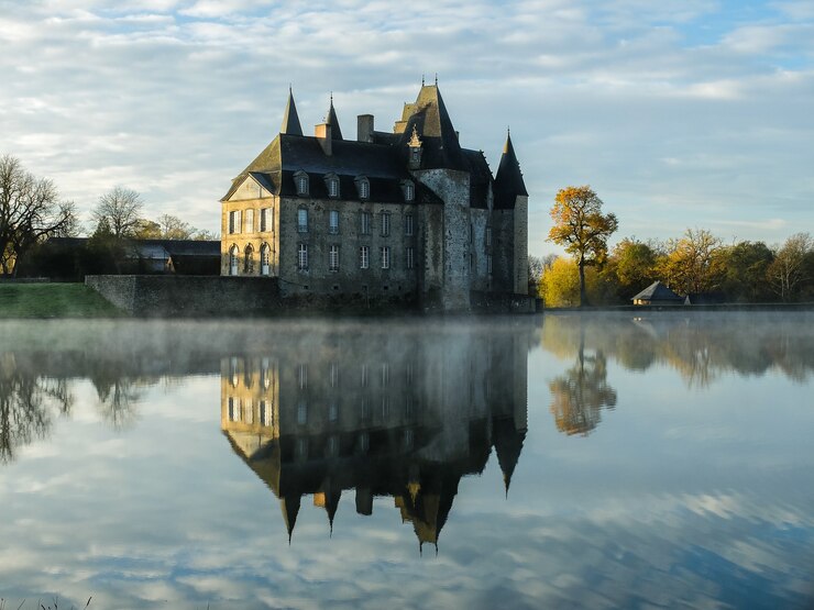 Free Photo clear lake with the reflection of a huge castle against the cloudy sky in autumn