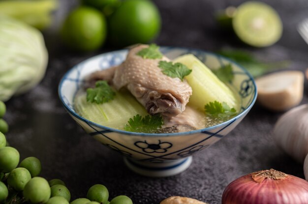 Прозрачный суп с курицей и зеленью с чесноком, лимоном, луком, красным луком, грибами и базиликом