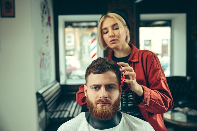 Client during beard shaving in barbershop.