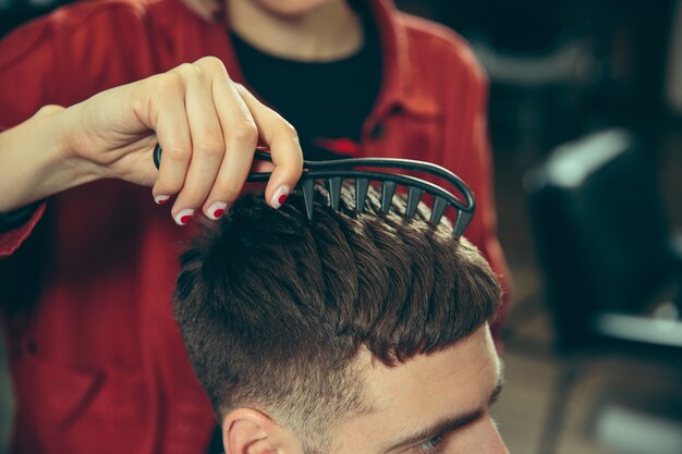 Client during beard shaving in barbershop.