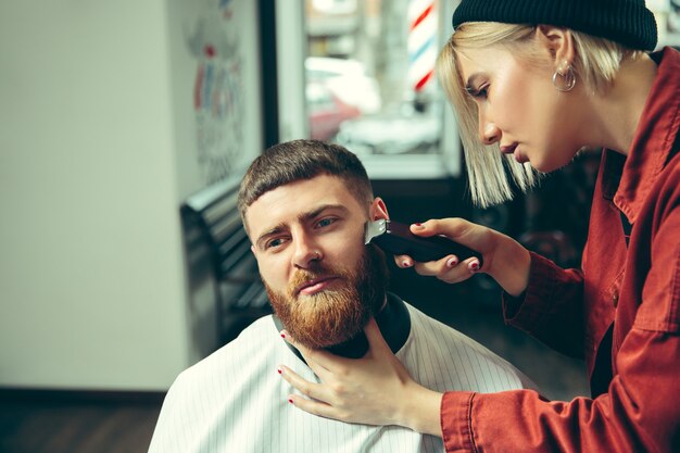 Клиент во время бритья бороды в парикмахерской.
