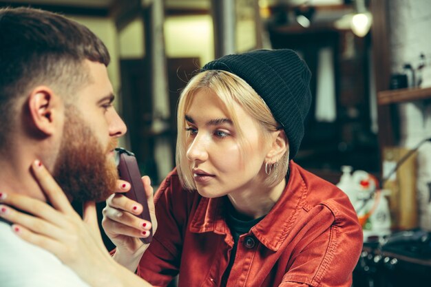 Client during beard shaving in barbershop.