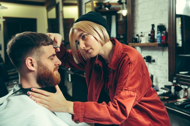 Client during beard shaving in barbershop.