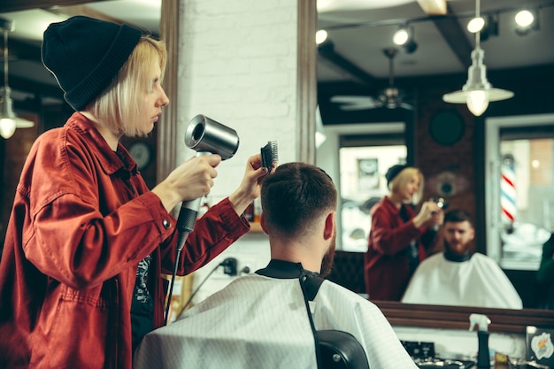 Client during beard shaving in barbershop.