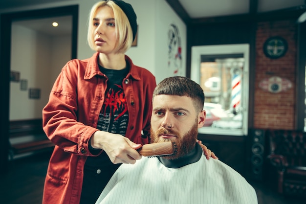 Клиент во время бритья бороды в парикмахерской