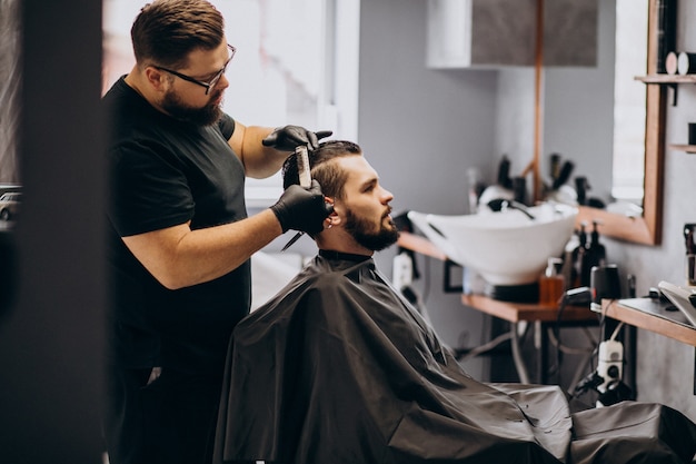 Client doing hair cut at a barber shop salon