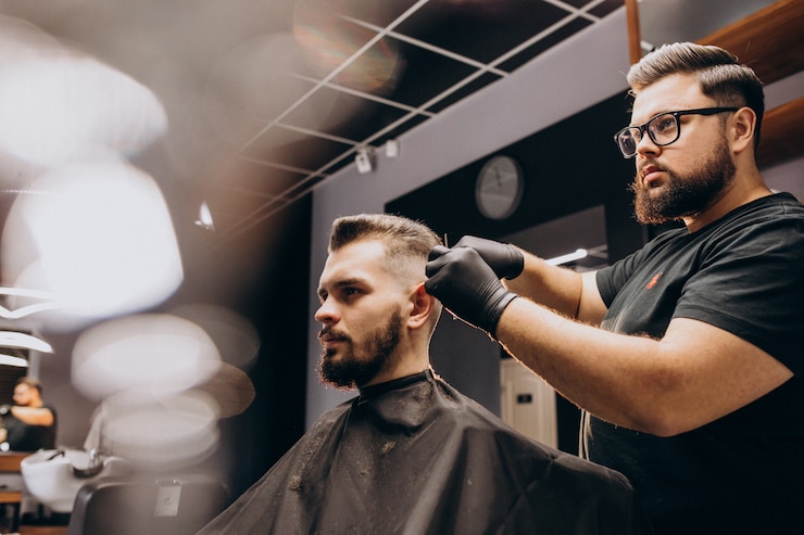 Free Photo client doing hair cut at a barber shop salon