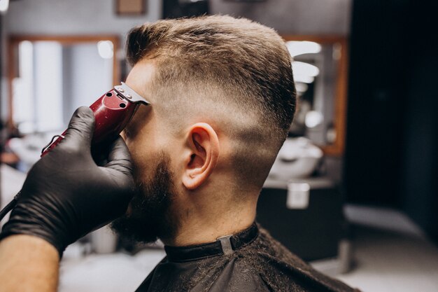 Client doing hair cut at a barber shop salon