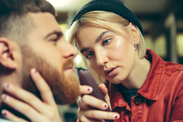 Foto gratuita cliente durante la rasatura della barba nel negozio di barbiere