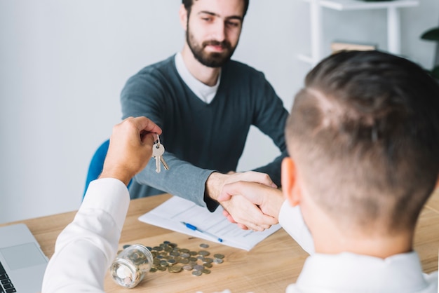 Client shaking hand of agent and looking at keys