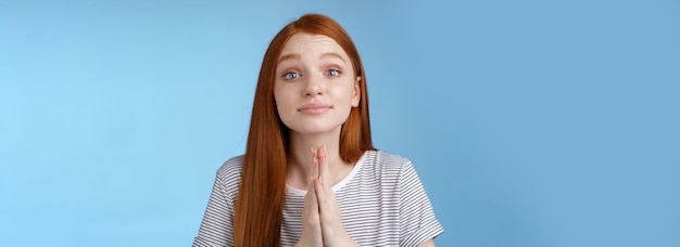 Free photo clingy cute nice redhead european girl asking favour cup hands together pray gesture say please