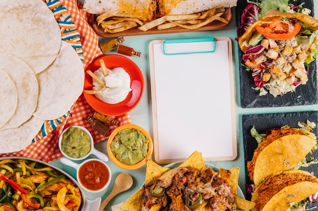 Free photo clipboard among tasty mexican dishes