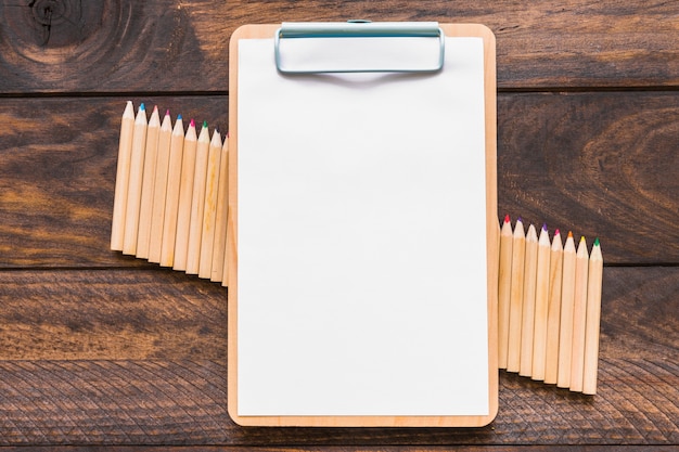 Clipboard lying on set of pencils