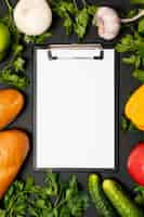 Free photo clipboard mock-up surrounded by fresh veggies