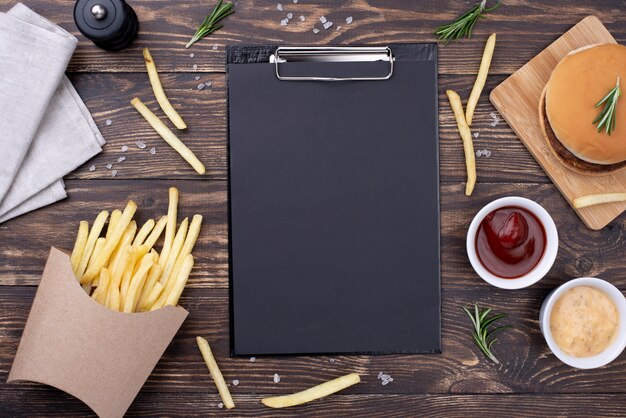 Clipboard on table with hamburger and fries