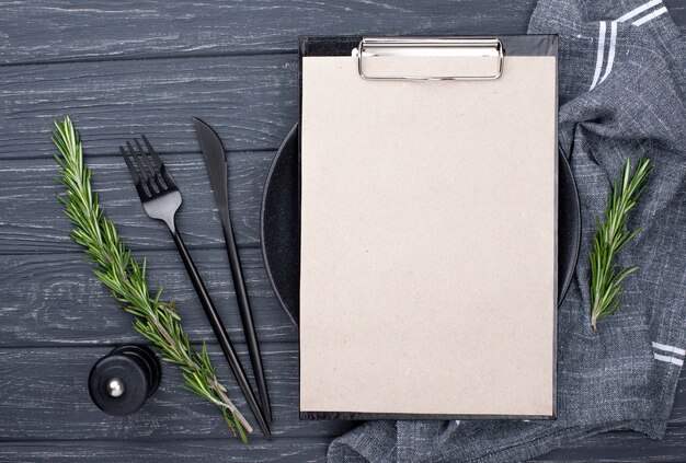 Clipboard on table with plate and cutlery