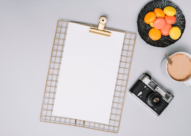 Free photo clipboard with camera, cookies and coffee