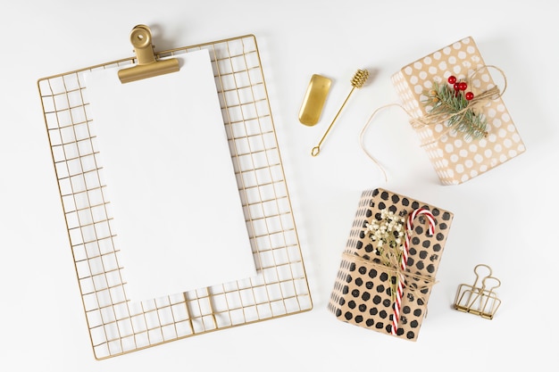 Clipboard with Christmas gift boxes on table