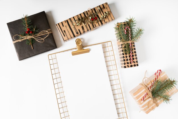 Clipboard with Christmas gifts on table