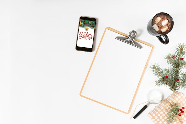 Free photo clipboard with christmas inscription on smartphone screen