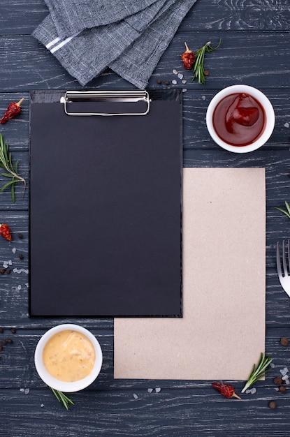 Free photo clipboard with cutlery  setting and souces