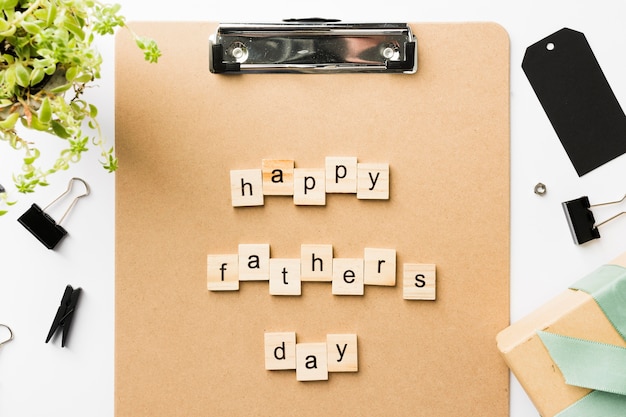 Clipboard with happy fathers day message on table