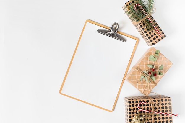 Free photo clipboard with small gift boxes on light table