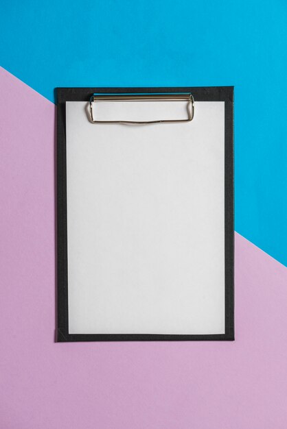 Clipboard with white sheet over color papers