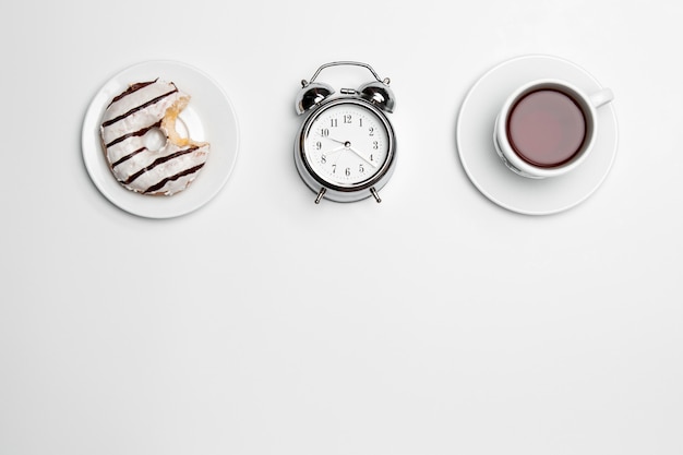 흰색 표면에 시계, 컵, 케이크