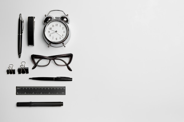 Часы, ручка и очки на белой поверхности