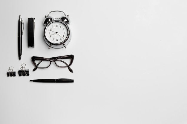 clock, pen, and glasses on white