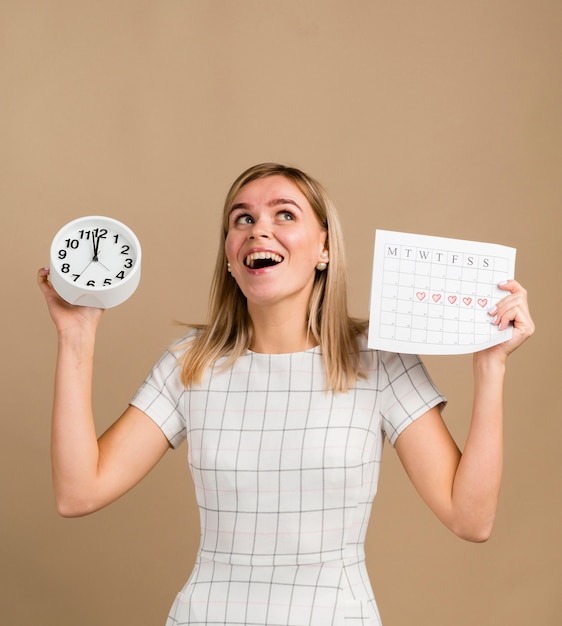 Clock and period calendar held by woman