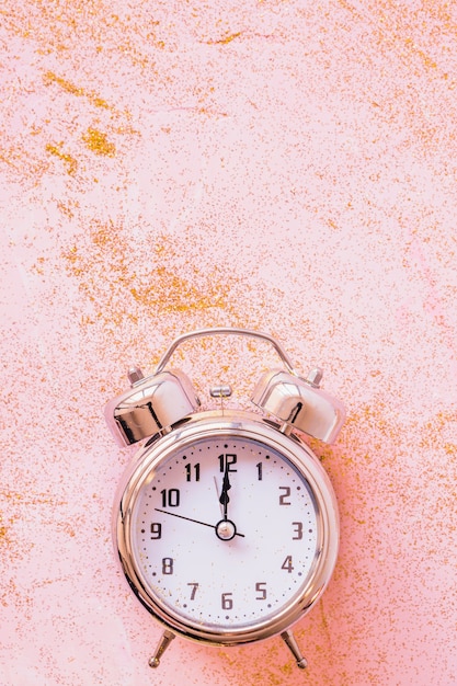 Clock with sequins on pink table 