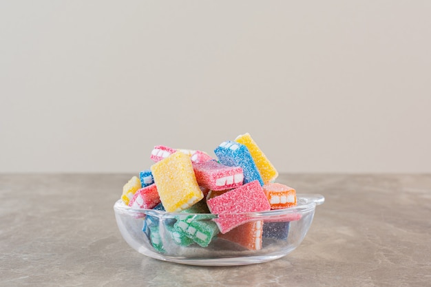 Cloe up photo of homemade colorful candies in bowl over grey.