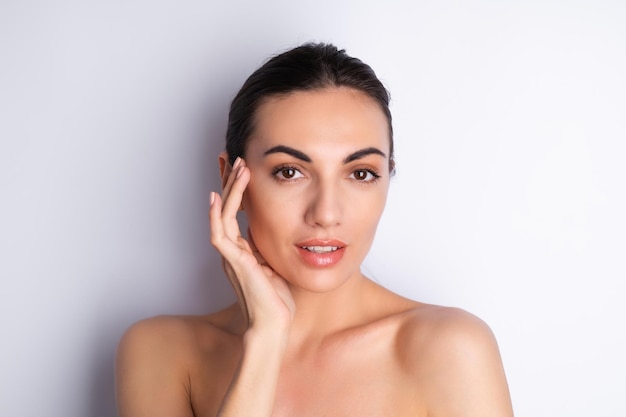 Close beauty portrait of a topless woman with perfect skin and natural makeup plump nude lips on a white backgroundx9