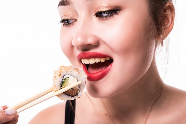 Close portrait of a beautiful woman eating sushi rolls