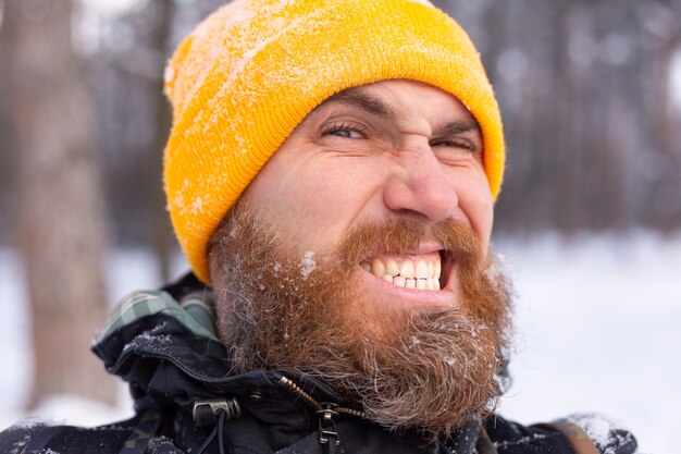 雪に覆われた森の中で、すべて雪の中で顔をしているひげを生やした男の肖像