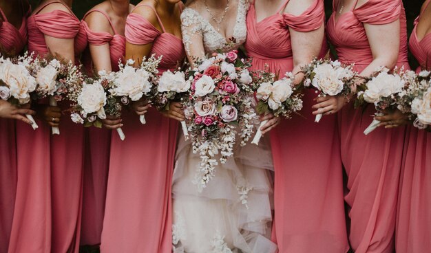 Close shot of a bride with her bridesmaids holding flowers