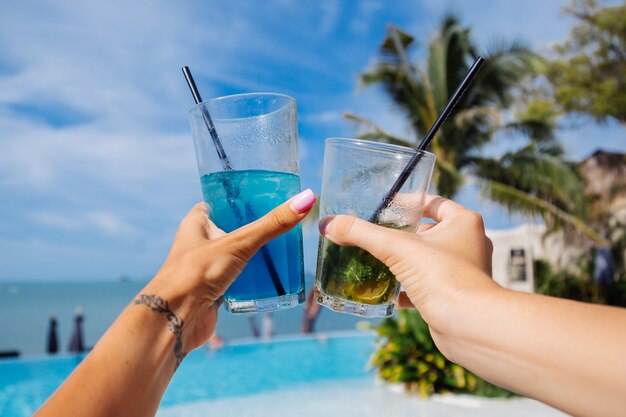 Close shot of hands hold alcohol cocktails