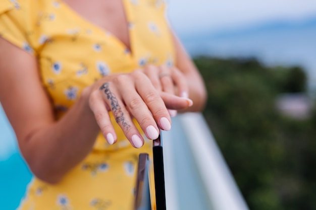 Close shot of womans manicure hands, wearing ring on finger.