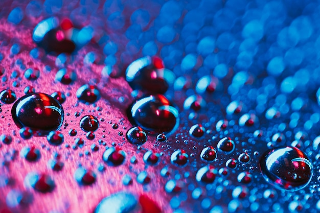 ピンクと青の背景を持つ抽象的な水の泡のクローズアップ