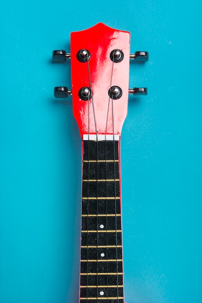 Close-up of acoustic classic guitar head on blue background